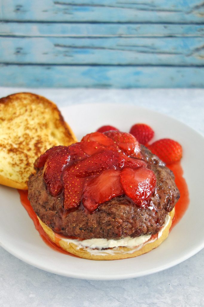 The strawberry french toast burger has a french toasted bun, cream cheese and is topped with strawberries.