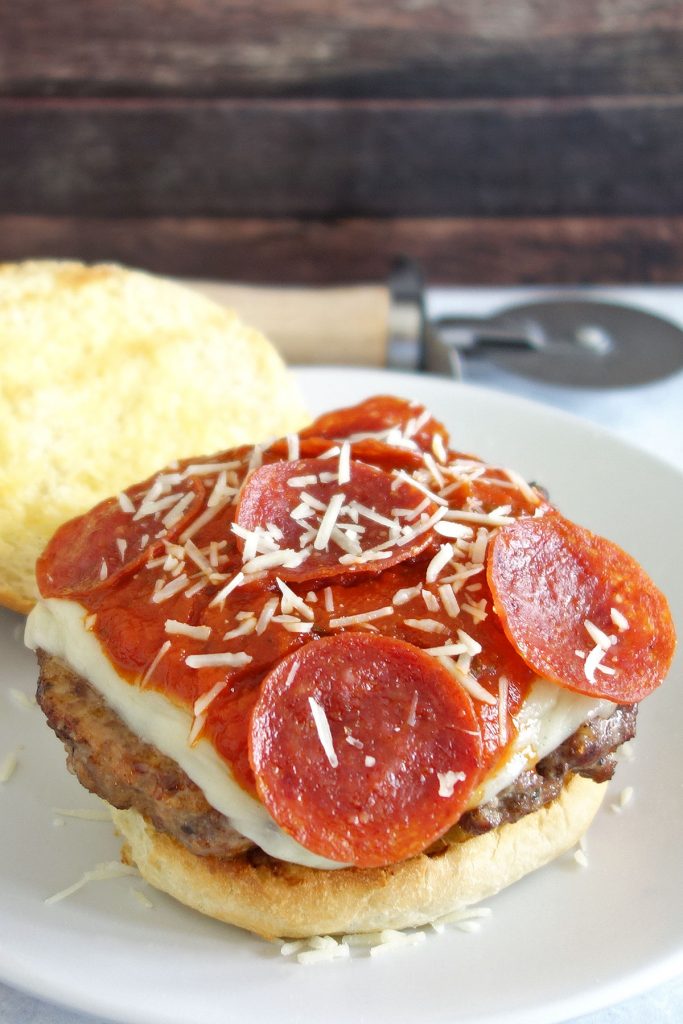 The pizza burger is a delicious Italian sausage burger topped with traditional pizza toppings like pepperoni mozzarella and parmesan cheese.