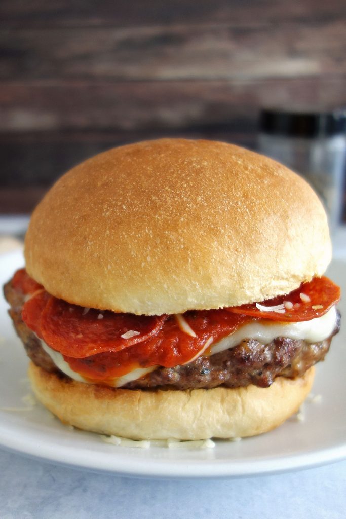 The pizza burger is a delicious Italian sausage burger topped with traditional pizza toppings like pepperoni mozzarella and parmesan cheese.